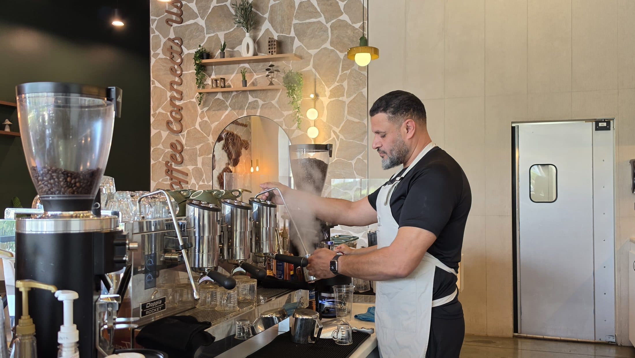 Pulling shots at the espresso bar in Qurbah House of Coffee